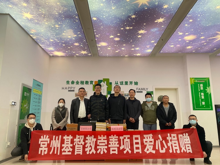 Volunteers from the Chongshan Fund affiliated with faith-based Amity Foundation took a group picture after donating computers and office supplies to the Lezhu Community Shelter Center for the autistic in Zhonglou District, Changzhou, Jiangsu, on March 31, 2023. 