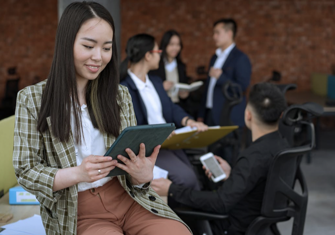 A picture of a girl at work looking at a ipad