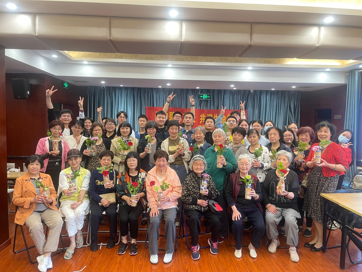 Elderly residents from Hubin Street community in Hangzhou and university student volunteers in Zhejiang took a group picture with flowers in discarded plastic water bottles or glass bottles during a series of environmental protection activities carried out by Hangzhou YWCA from late March to late April, 2023.