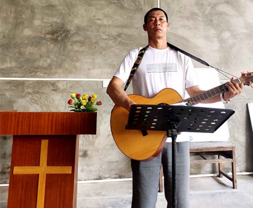 Deng Xiaochun, who was once a drug addict for 20 years, played a guitar in a church at an unknown date.