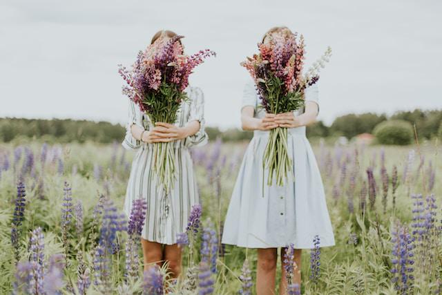 A picture of two girls holding two bouquets of flowers