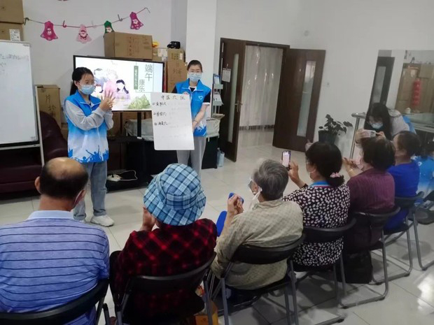 A nursing student from Zhenjiang College in Jiangsu taught the elderly in the community acupuncture points at the Reed's Home Volunteer Service Center on June 2, 2023.