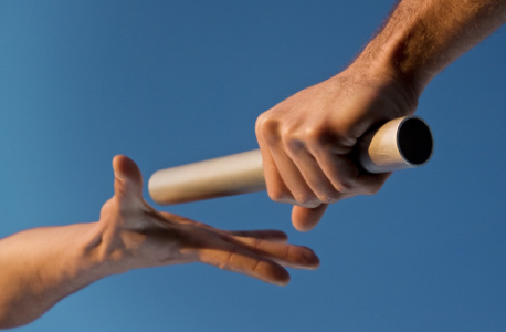 Two hands passing a relay baton