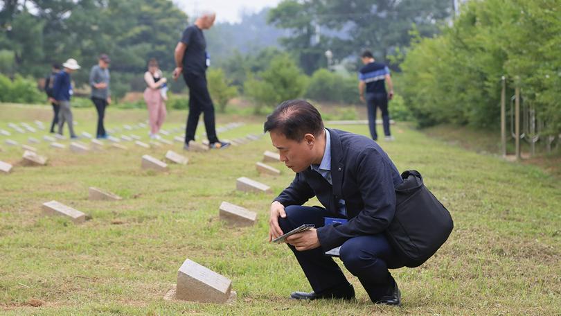Chang-Hwan Kim looks at a headstone in South Korea’s Cemetery for North Korean and Chinese Soldiers, known informally as the “enemy cemetery,” on June 7 as part of an outing during the Christian Forum for Reconciliation in Northeast Asia in Paju.