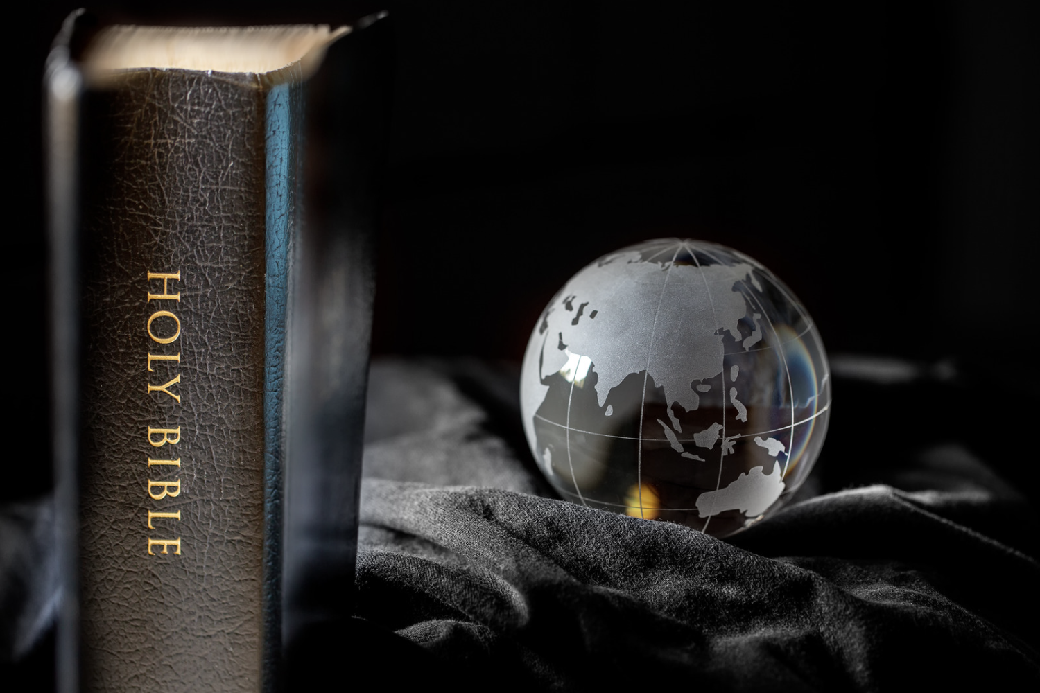 A picture of the Holy Bible with a glass globe