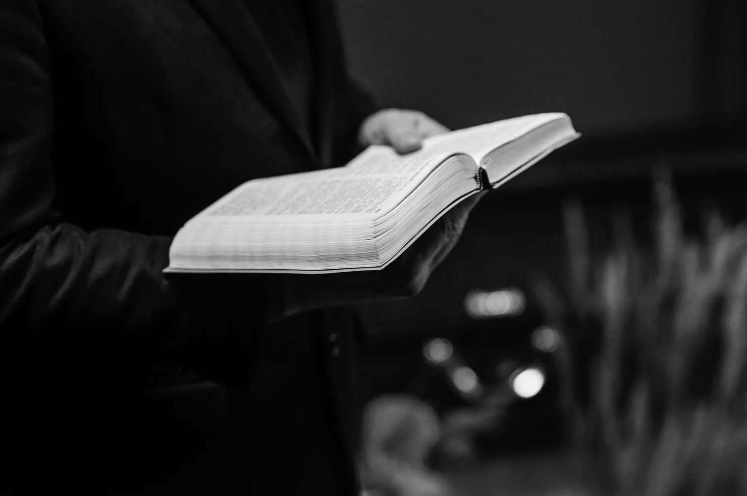 A person holds an open Bible.