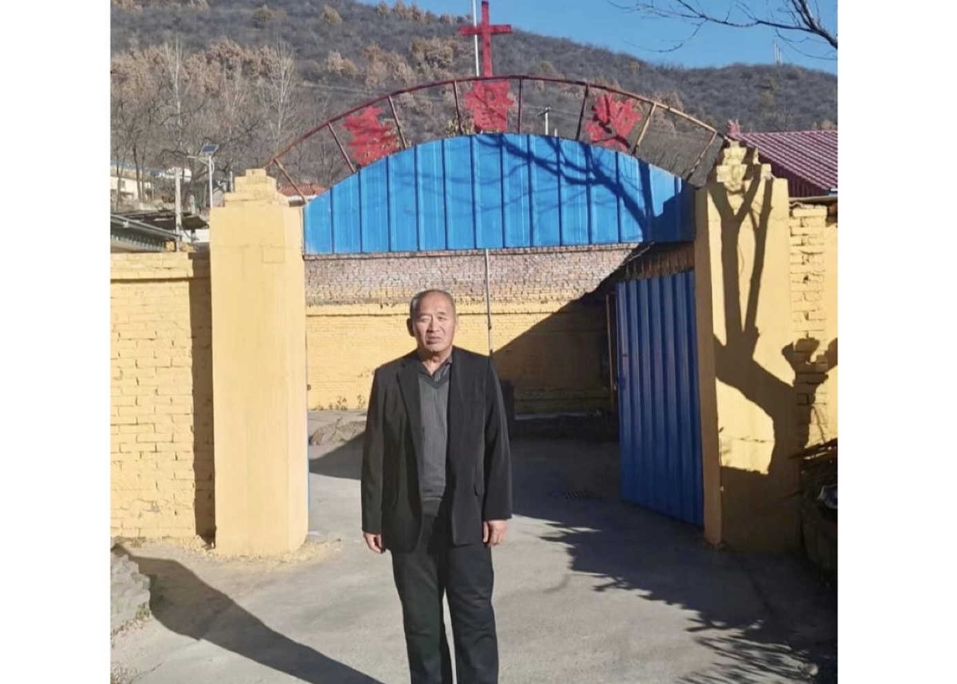 A picture of Qu Guoping standing in front of a church