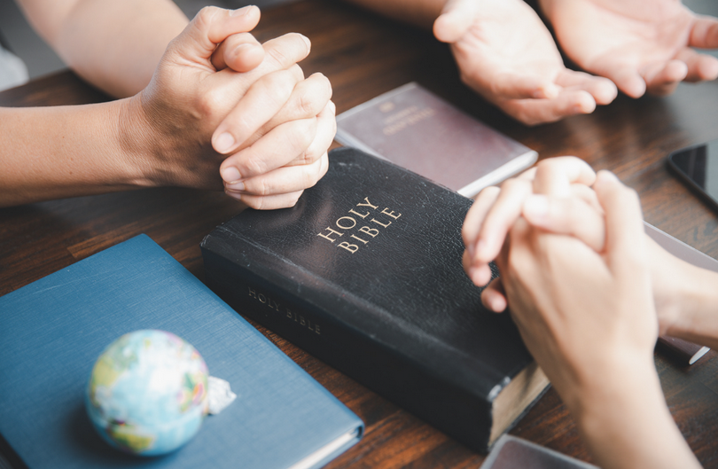 A small group of Christians pray together.