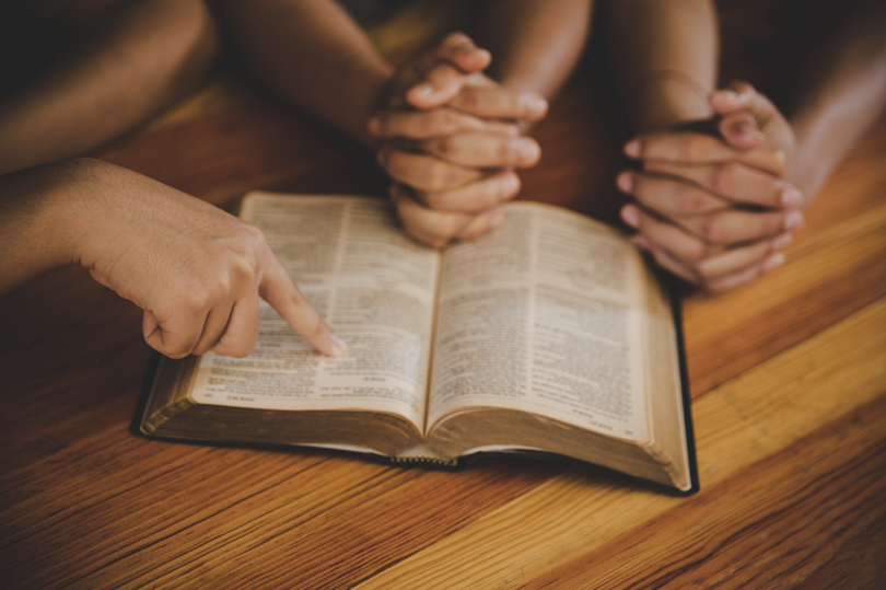 A small group of people study the Bible.