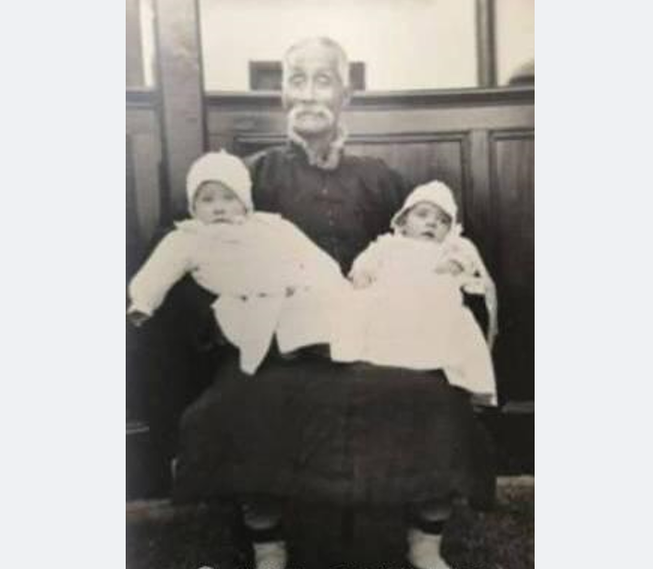 A historical picture of Rev. Zhang Chengzhai holding two foreign infants