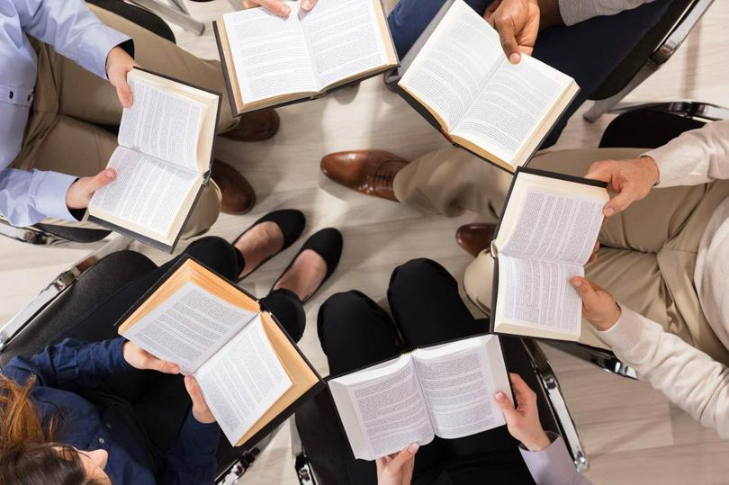 A picture of a  group of people reading books