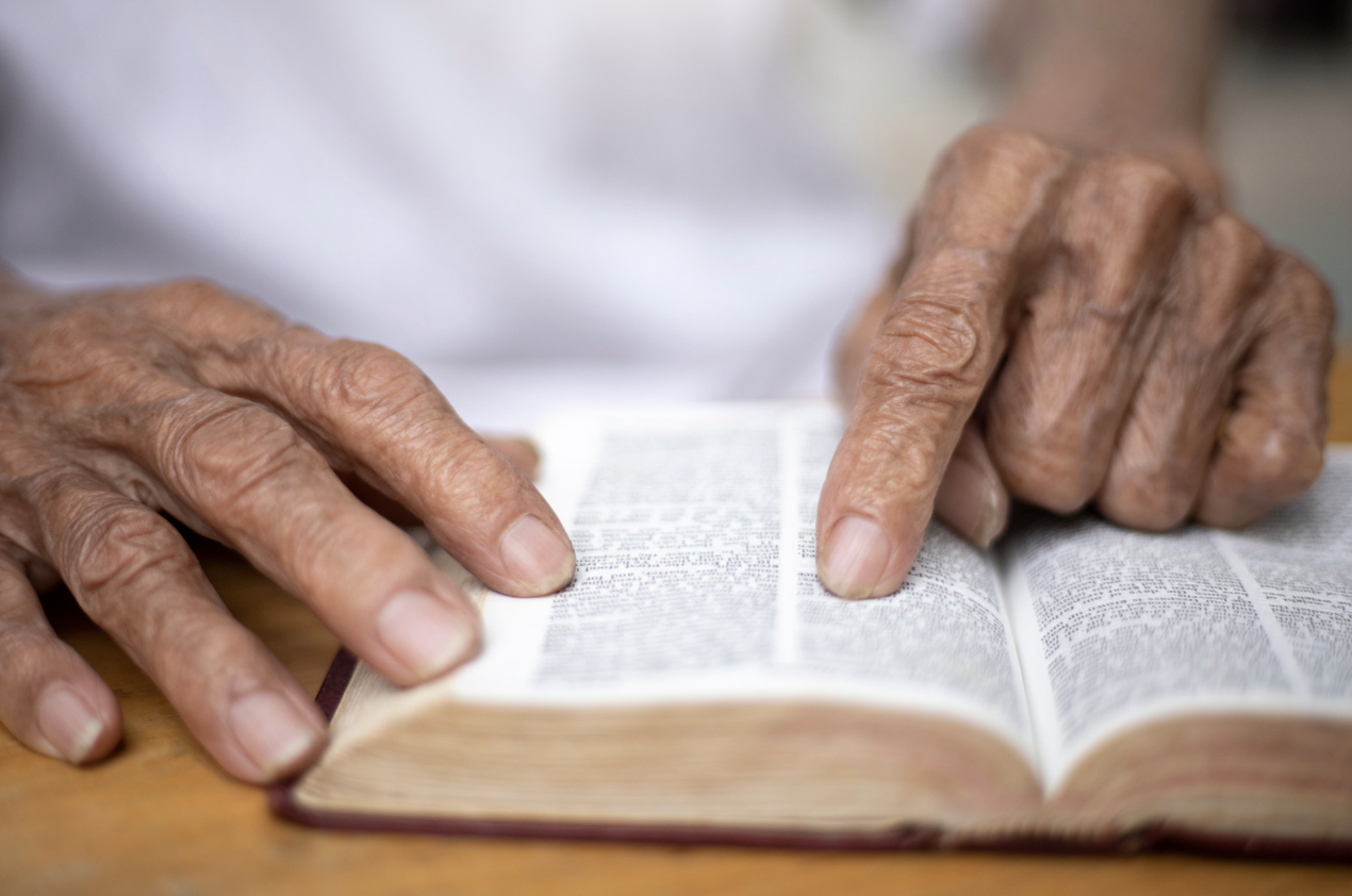 A picture of an old man reading the Bible