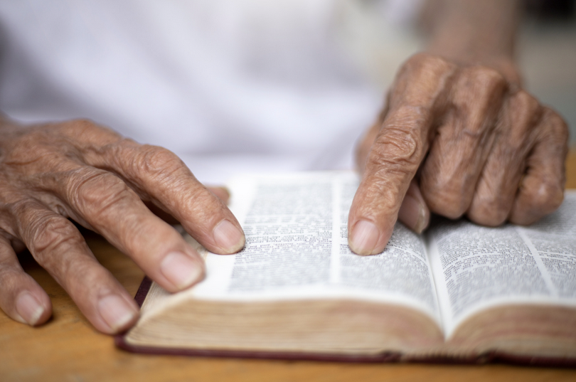 A picture of an old man reading the Bible