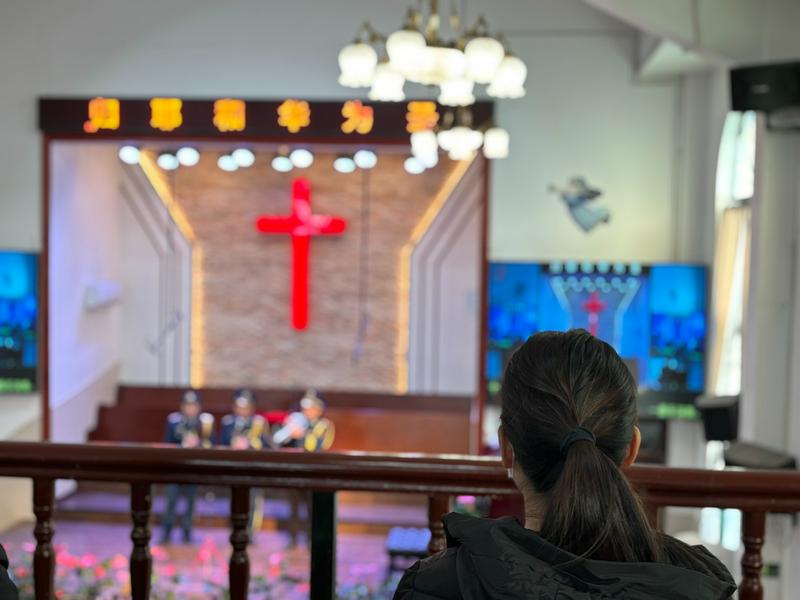 A picture of a woman sitting in the Gongchen church's chapel in Hangzhou City, Zhejiang Province