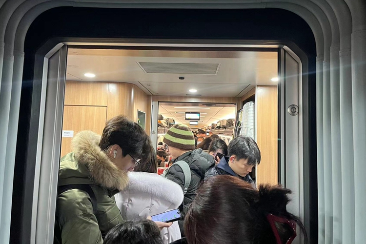 A picture of Spring Festival travelers swiping their mobile phones on a high-speed train