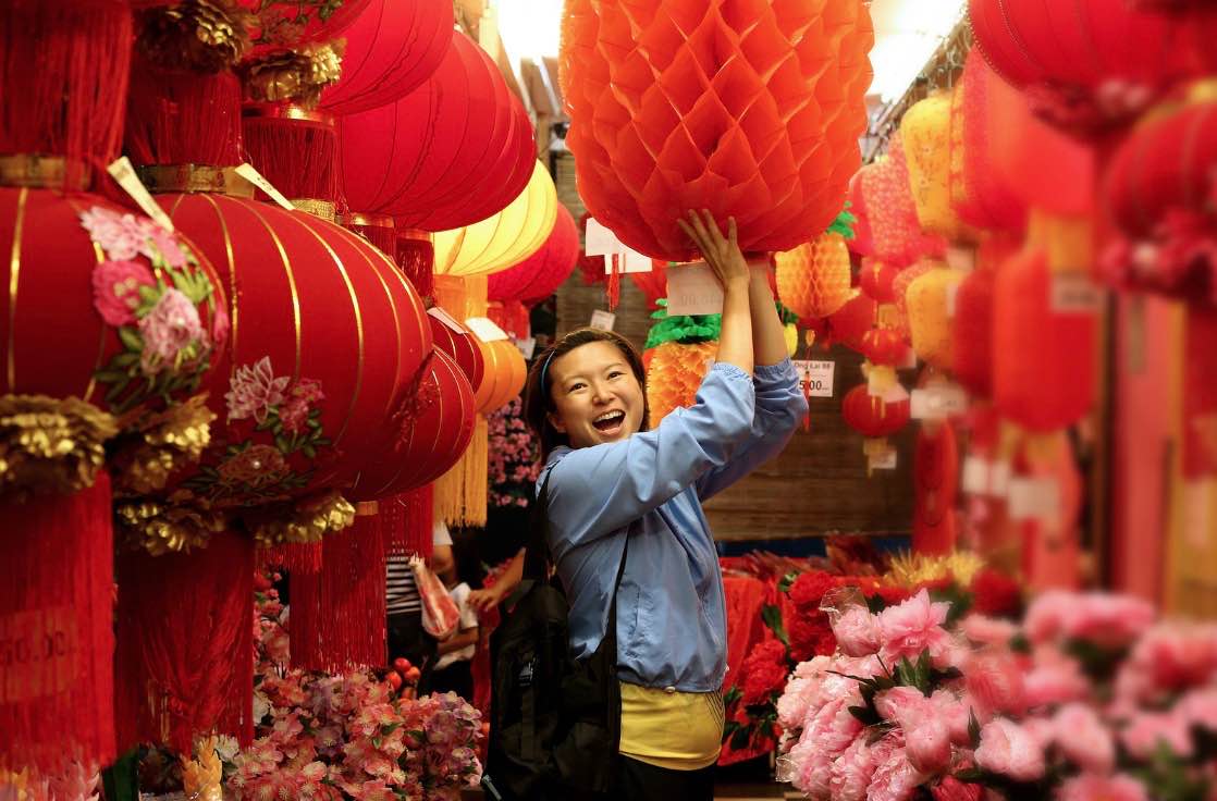 A picture of a cheerful woman with Chinese New Year decorations