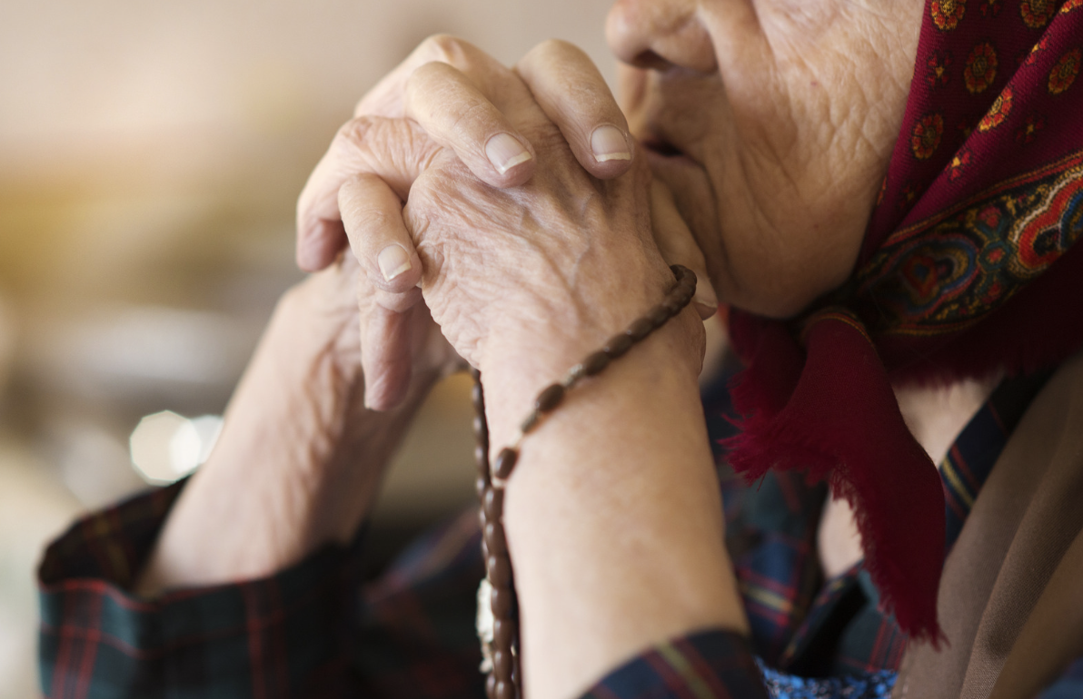 An old woman prays.