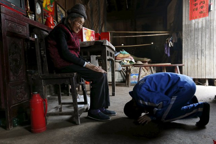 A picture of a young man kneeling and kowtowing before an old woman