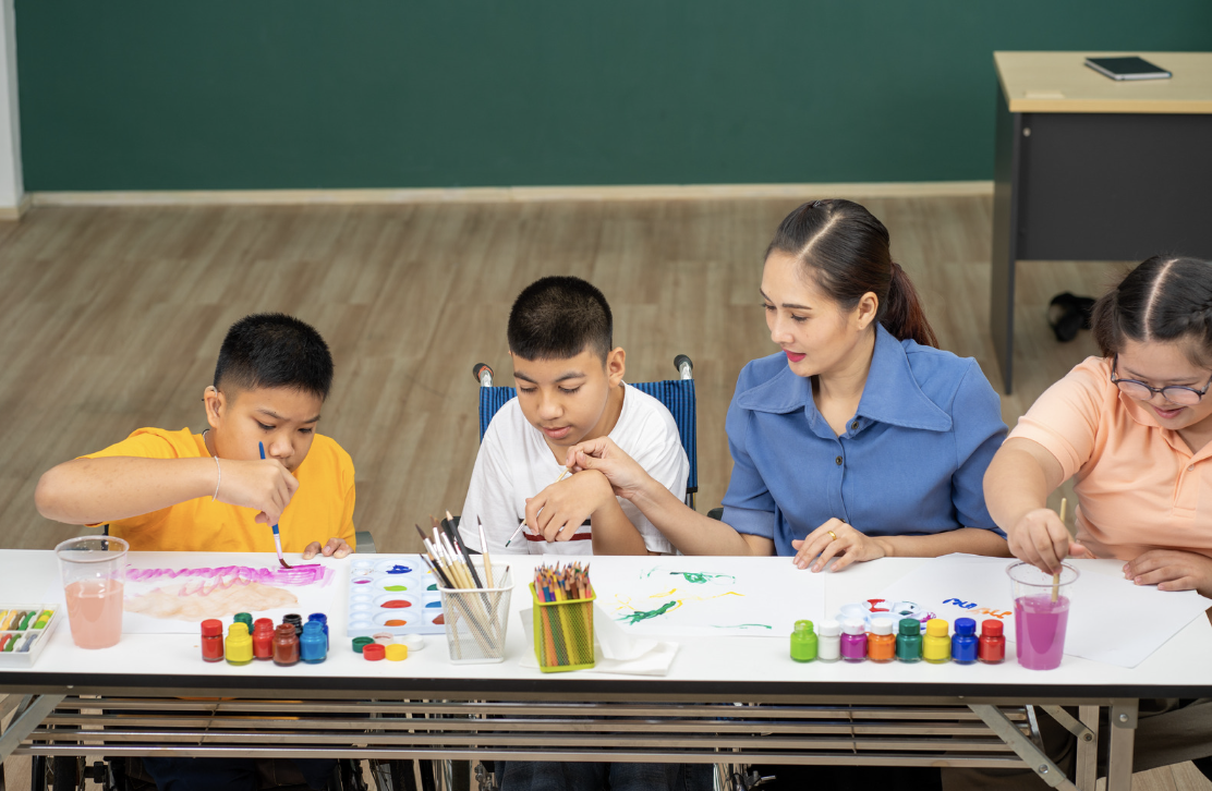 Children with autism are learning to color paint in the classroom.