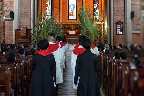 Choir members and pastors entered the main building with palm branches to observe the Palm Sunday service conducted at Holy Trinity Cathedral in Shanghai on March 24, 2024.
