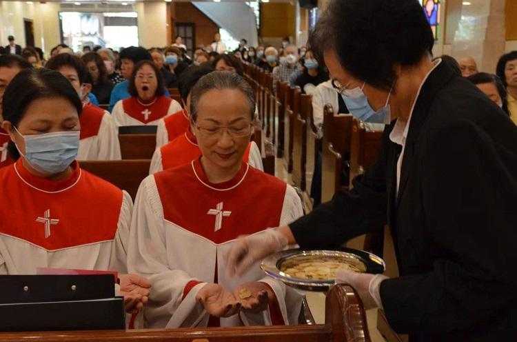 Choir members of Zion Church received the bread during the church's Good Friday communion service in Guangzhou, Guangdong, on March 29, 2024.