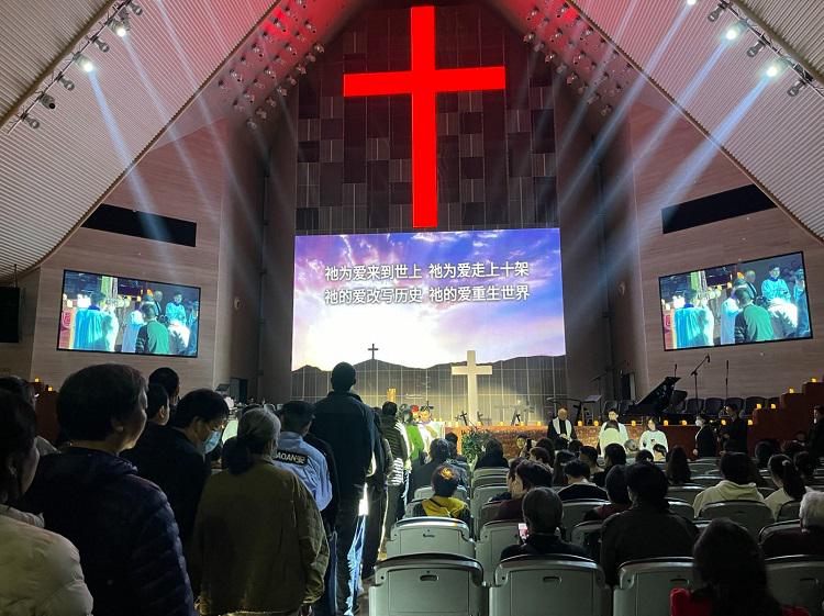 Believers were queueing up to fetch cross necklaces from a large cross at the altar to wear during a Good Friday service at the International Church in Ningbo, Zhejiang, on March 29, 2024.