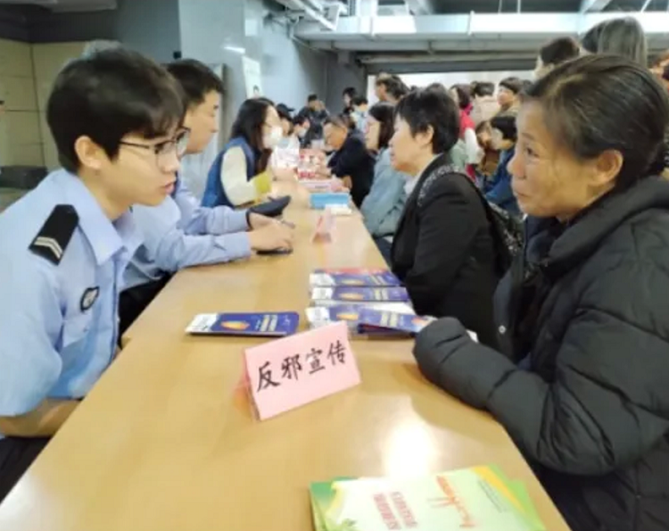 A local police officer gave anti-cult propaganda to a believer at Chongyi Church in Hangzhou, Zhejiang province, on May 12, 2024.