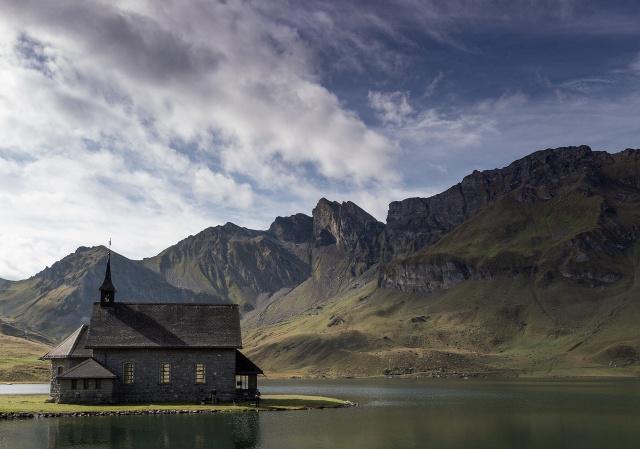 A church sits by a lake. 