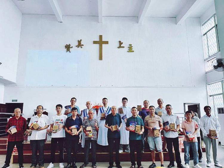 Male Christians and choir members took a group picture with gifts in their hands after the Father's Day service at Union Church in Guangzhou, Guangdong, on June 16, 2024.