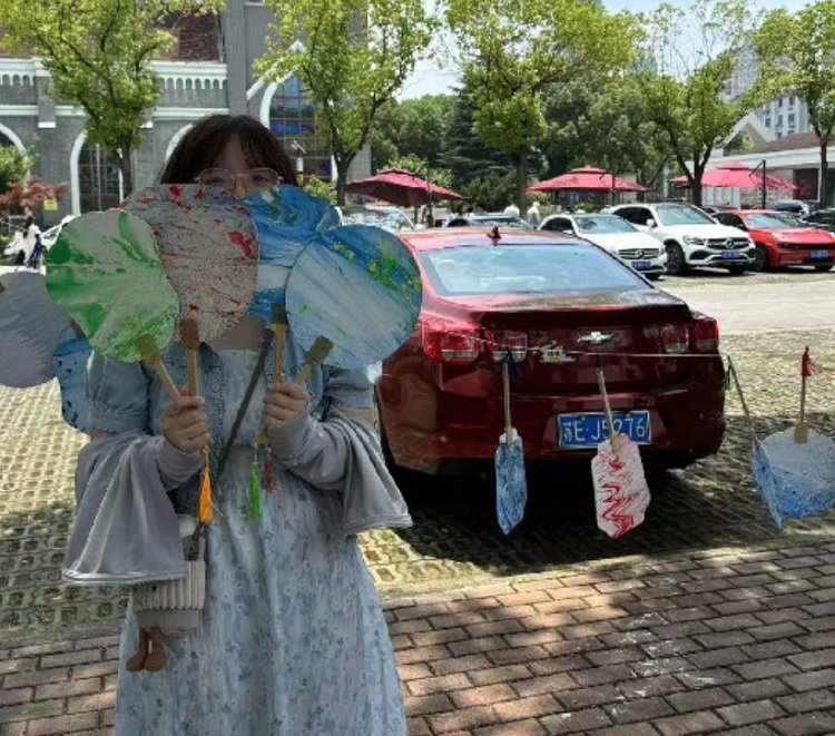 A believer held some lacquer fans outside Shishan Church in Suzhou, Jiangsu, which carried out an activity of making lacquer fans on June 9, 2024.