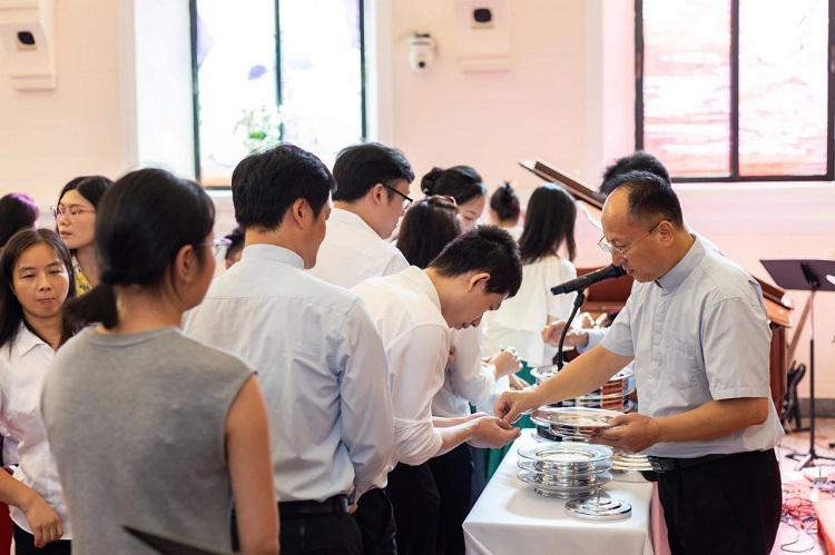 Rev. Lei Yuming, executive vice president of the Guangdong Christian Council, distributed the bread to young believers during a communion service at Shamian Church in Guangzhou, Guangdong, on July 7, 2024.