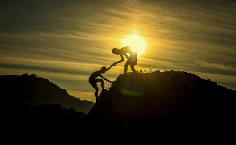 A picture of a man pulling another man on a mountain