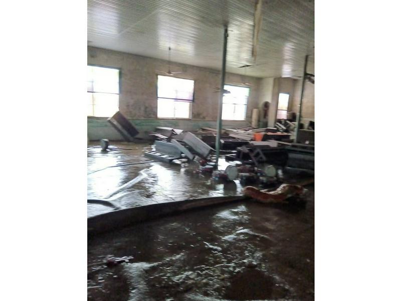 An interior picture of the flood-affected Tuanxin Church, with its floor covered with black silt and furniture scattered