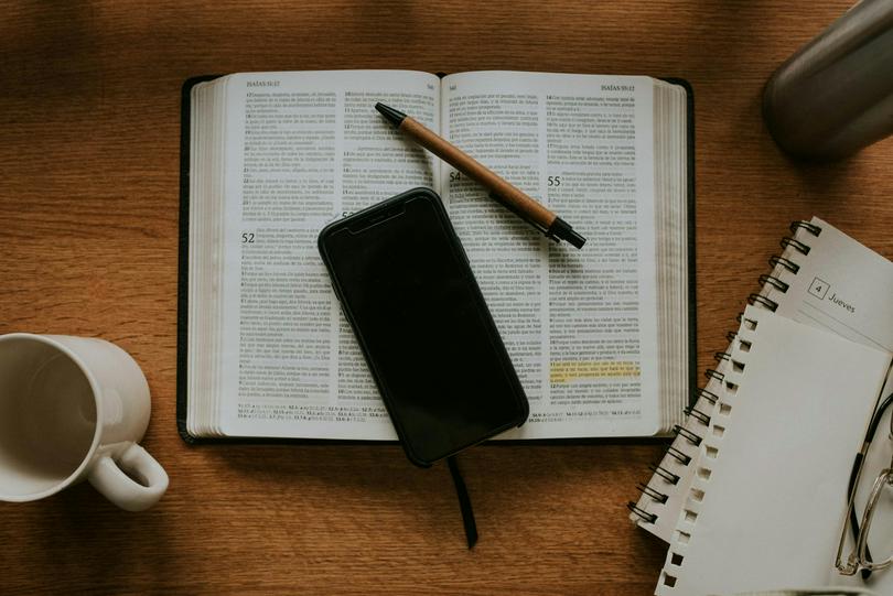 A phone and a pen on the Bible