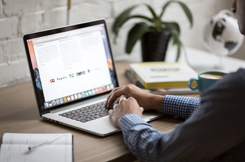 A man works with a laptop on a desk.