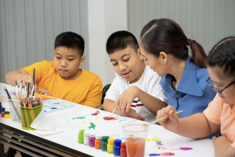 Children with autism are learning to color paint in the classroom.