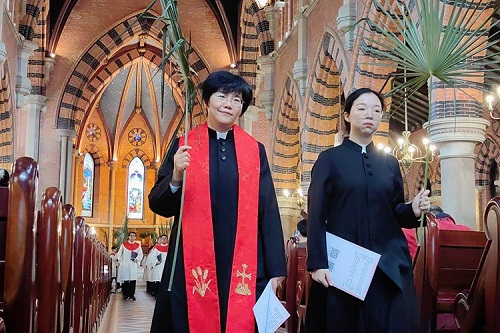 Rev. Lin Manhong, general secretary and vice president of the China Christian Council, and a clergywoman led the choir to enter the main building of Holy Trinity Cathedral in Shanghai with palm branches to observe the Palm Sunday service on March 24, 2024.