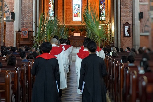 Choir members and pastors entered the main building with palm branches to observe the Palm Sunday service conducted at Holy Trinity Cathedral in Shanghai on March 24, 2024.