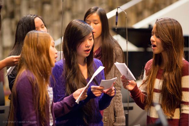 Young girls sing a song together. 