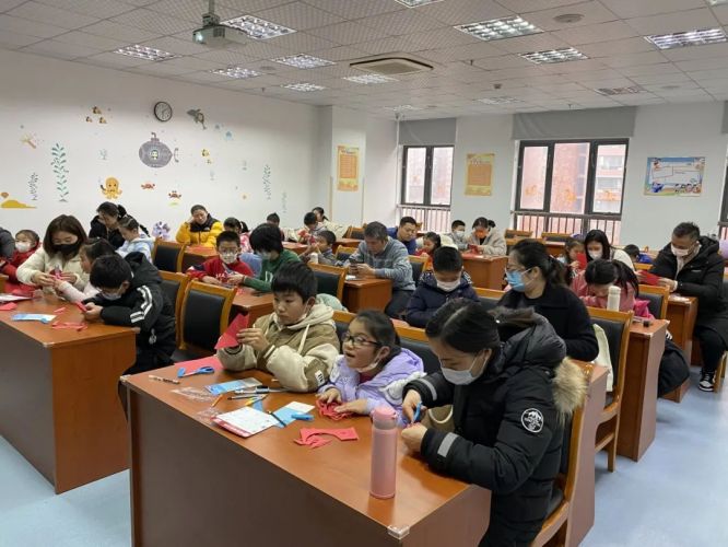 Children and their parents made paper-cutting crafts during the parent-child orientation hosted by the Gucun Town Xinjiayuan Community Cultural Activity Center of the Shanghai YMCA in Shanghai on January 20, 2024.