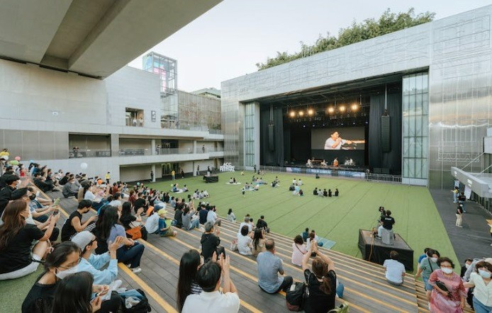 A picture shows many people watching a program in the stands at an unknown date.