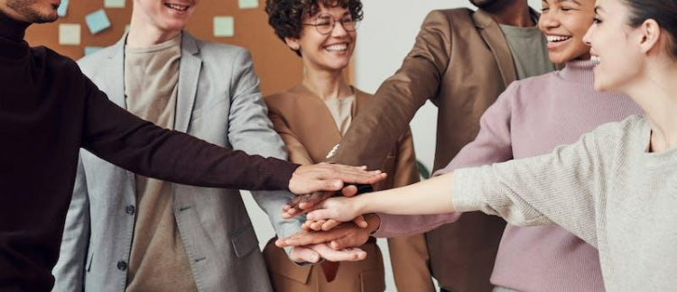 A picture shows some young men putting one of their hands together.