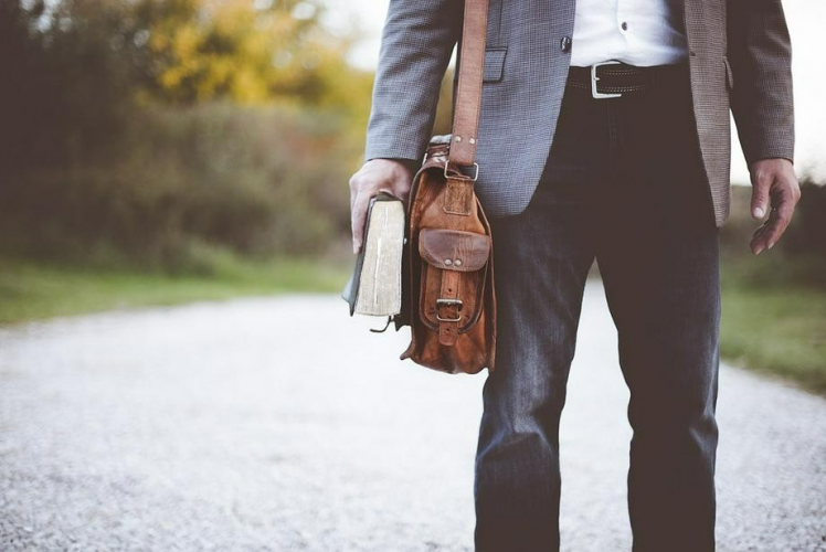 A picture shows a man with a bag and a book.