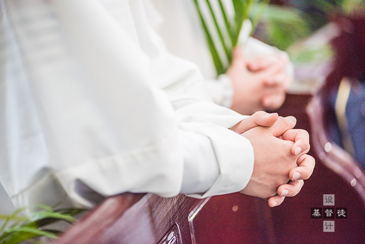 Two persons pray in a church.