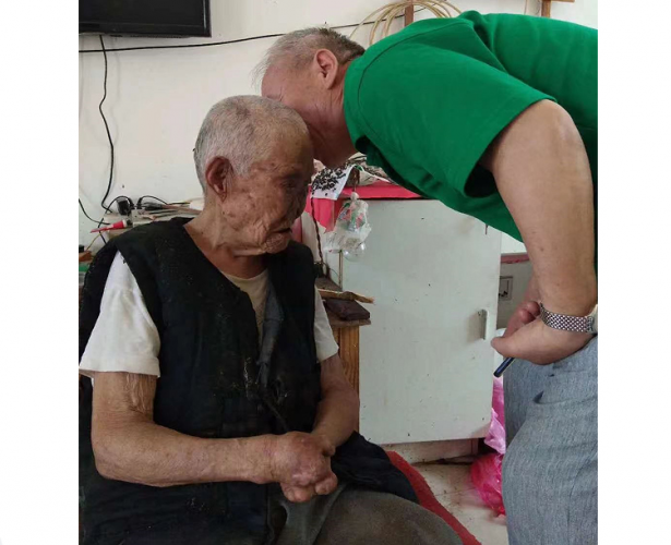 A picture of Wei Pu talking to a leper during a visit to him at an unknown date