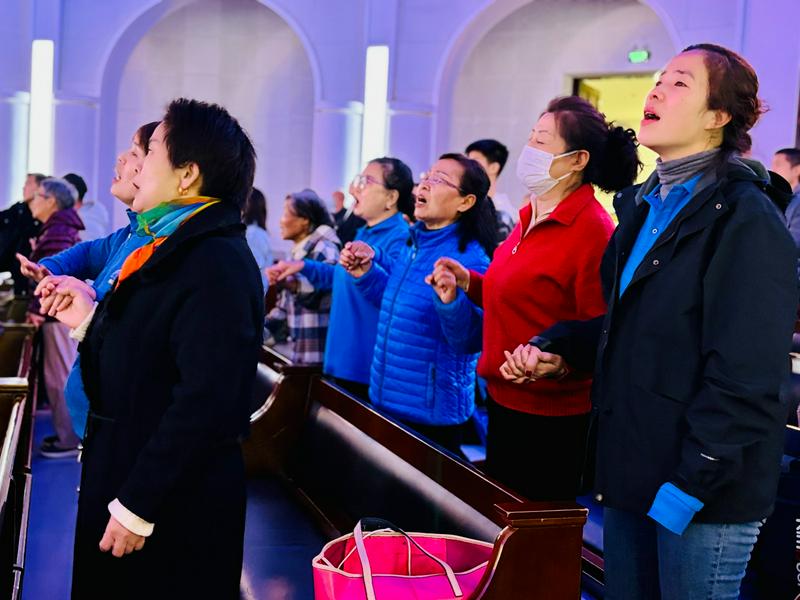 Attending believers stood up and sang with their hands holding together at a gathering marking Thanksgiving Day held at Fengtai Church in Beijing City on November 24, 2024.