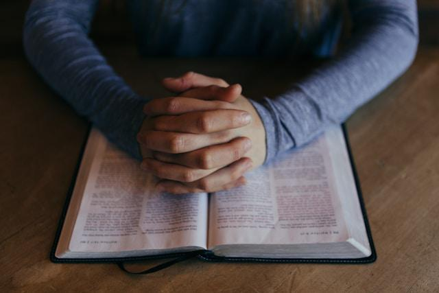 A picture of a man praying on the Bible