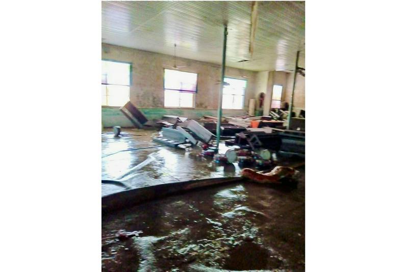 An interior picture of the flood-affected Tuanxin Church, with its floor covered with black silt and furniture scattered