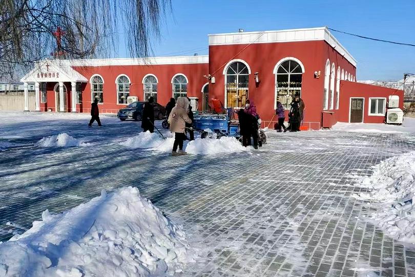 Church members cleared snow from the churchyard of a northern church on an unknown day. 