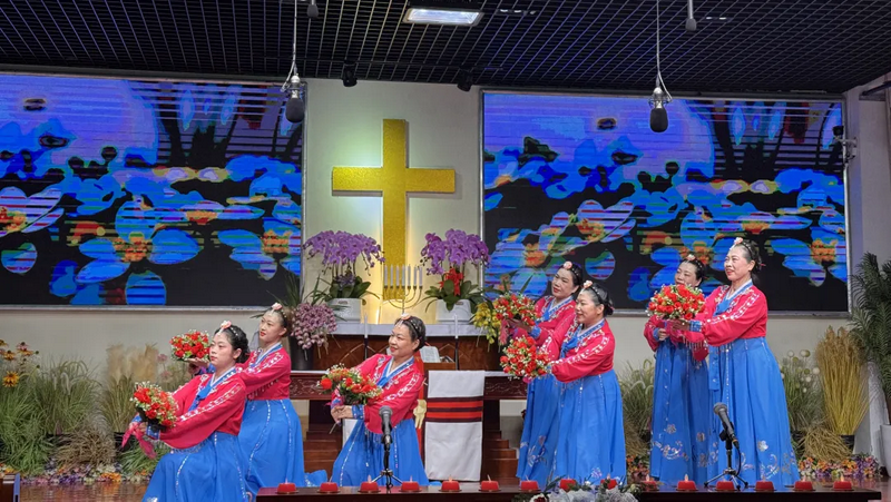 Christian women in blue and red ethnic costumes danced with flowers at a church in Beijing during Christmas Week 2024.